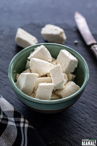 fresh homemade paneer placed in a blue color bowl