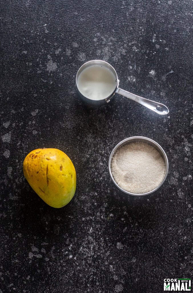 ingredients for mango milkshake arranged on a board