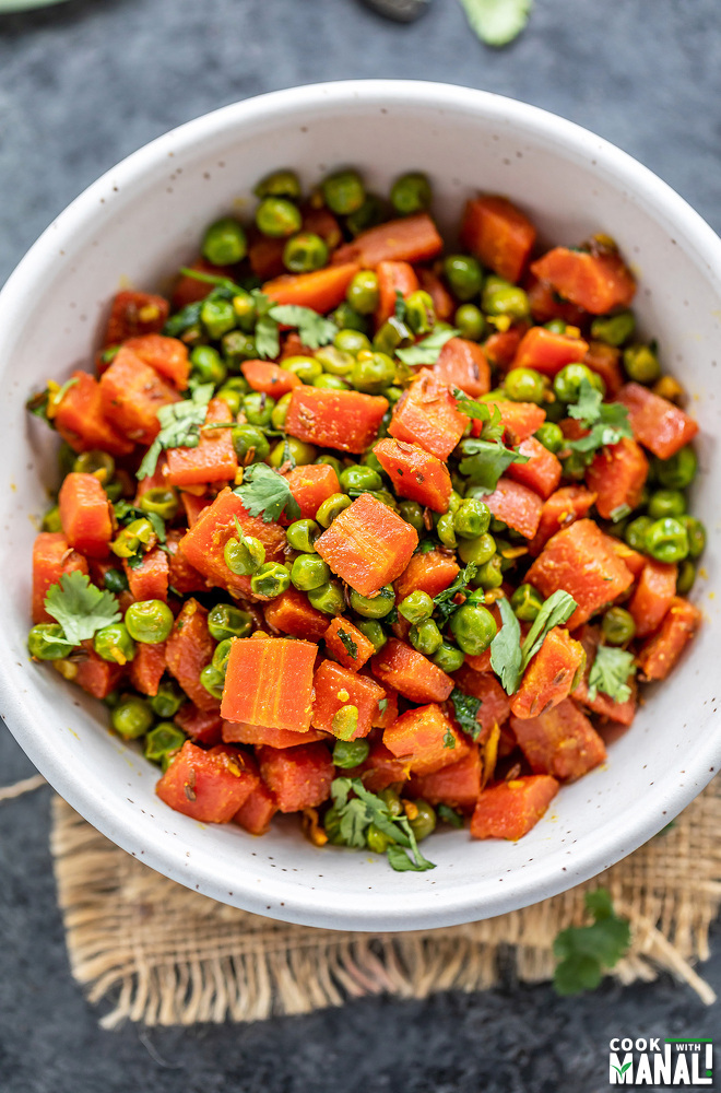 carrots and green peas stir fry served in a white bowl