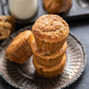 3 muffins stacked together with bottle of milk in the background