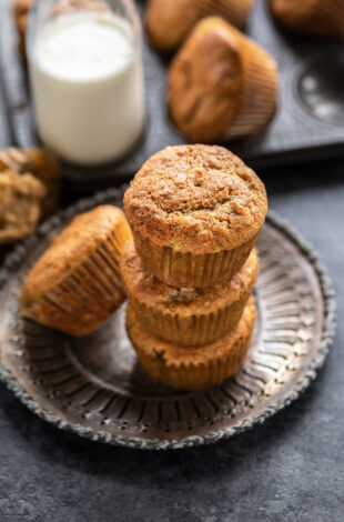 3 muffins stacked together with bottle of milk in the background