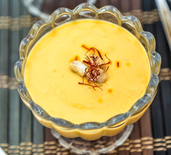 mango shrikhand served in a glass bowl, garnished with saffron