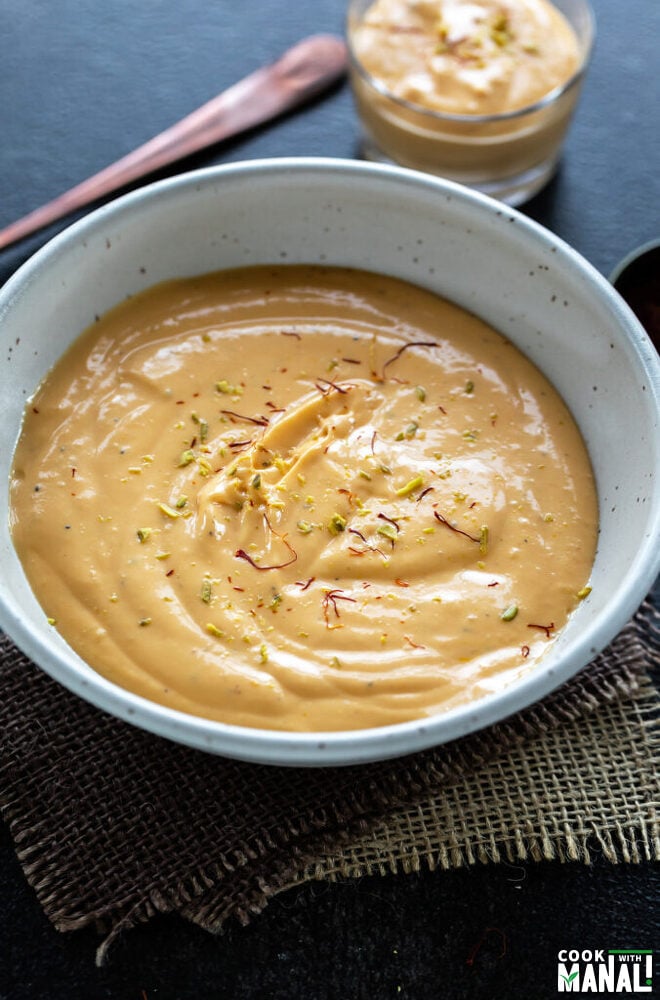 mango yogurt served in a white bowl garnished with saffron