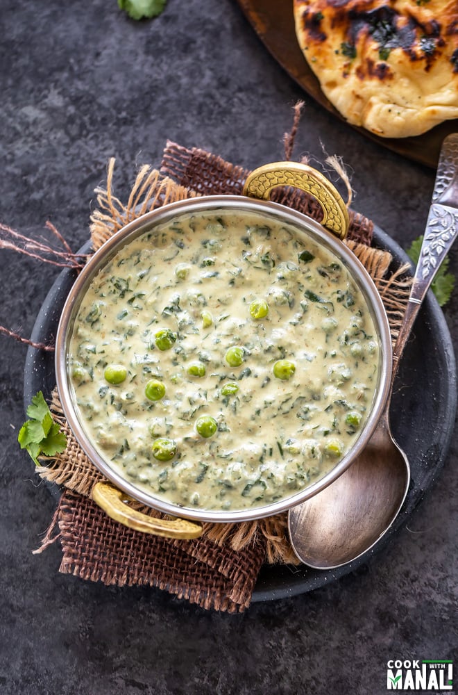 overhead shot of methi matar malai served in a copper kadai