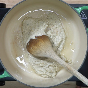 white thick paste being cooked in oil