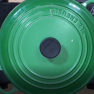 a green color pot covered with a lid