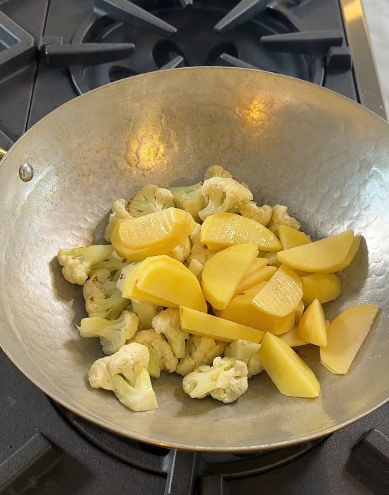 sliced potatoes and cauliflower in kadai