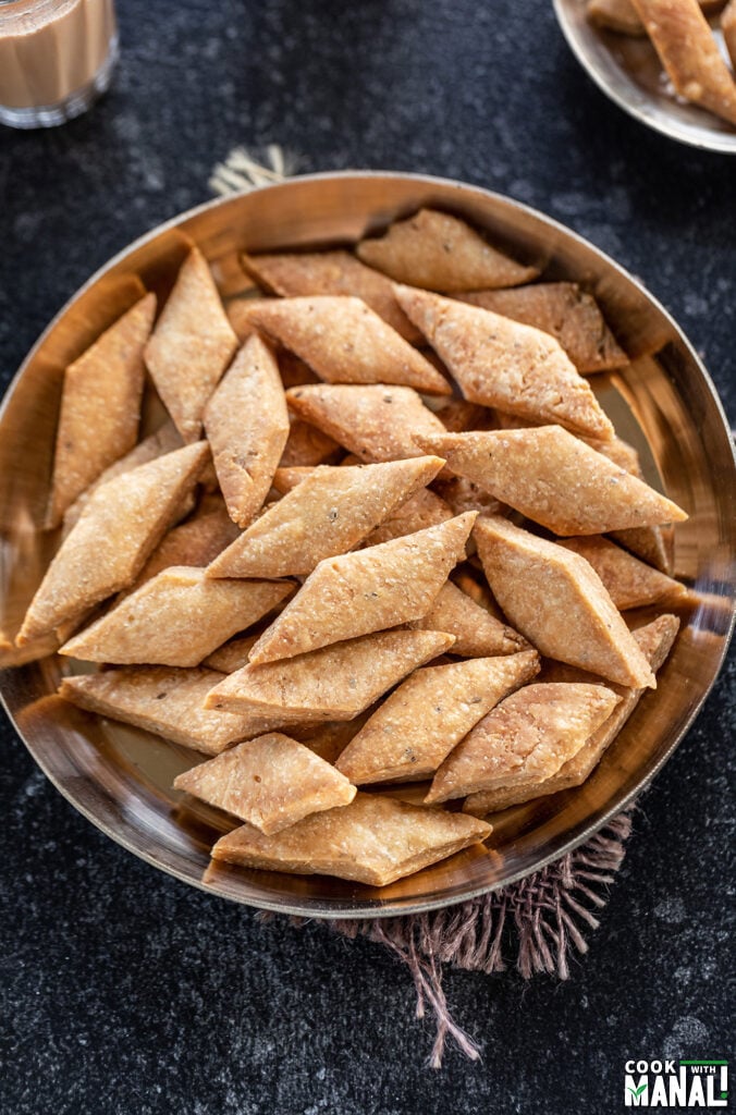 diamond shape namak para served in a bronze plate