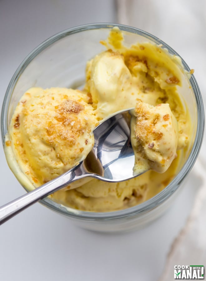 a spoon scooping out some ice cream served in a glass bowl