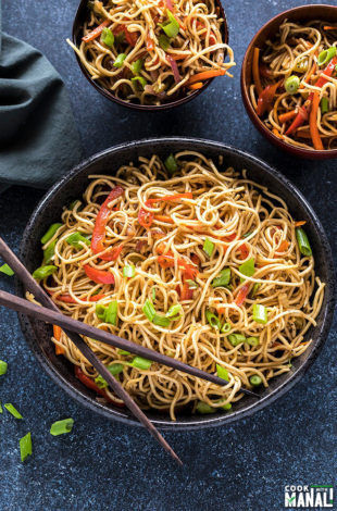 hakka noodles in a black bowl with a pair of chopsticks