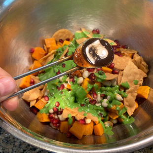 chutney being added to a bowl of diced sweet potatoes, chutney, pomegranate