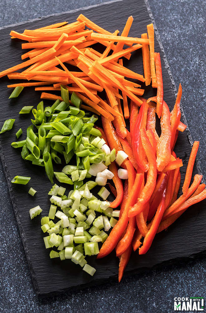 sliced vegetables like carrot, pepper on a black board