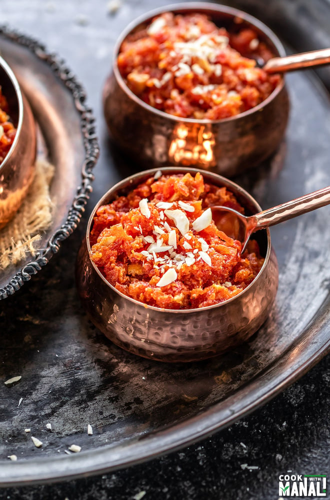 gajar halwa served in a small copper bowl with a small spoon