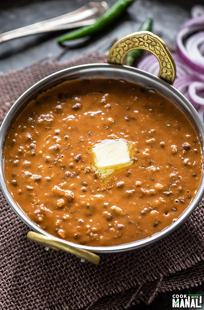 dal makhani in a copper kadai with a pat of butter
