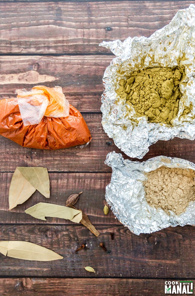 photograph of packets of spices like fennel powder, bay leaf, ginger powder and red chili powder