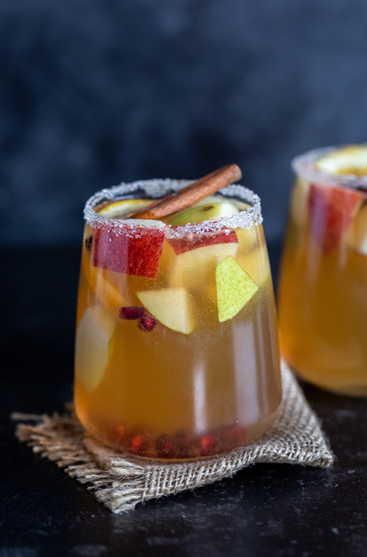 apple cider in a glass filled with fruits like apple, pears 