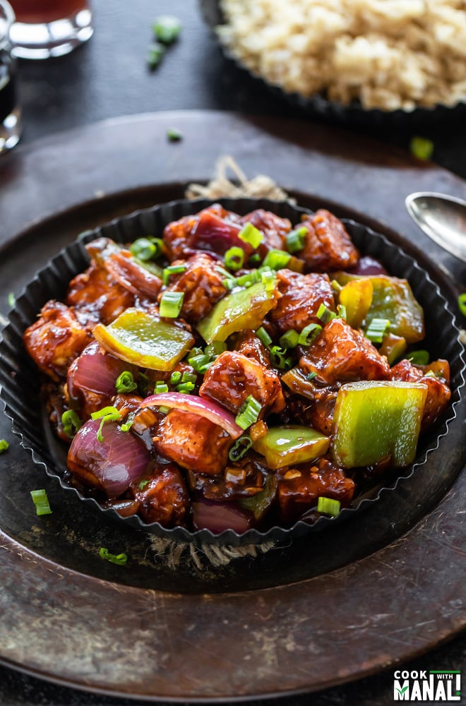 chilli paneer in a black rimmed plate