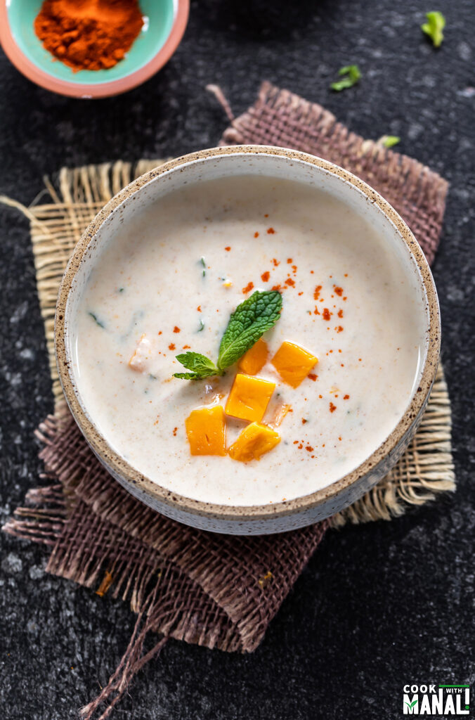 yogurt topped with mango and mint, served in a white bowl