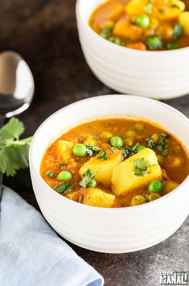 potato and peas curry served in a white bowl