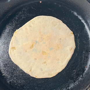 paratha being cooked on a skillet