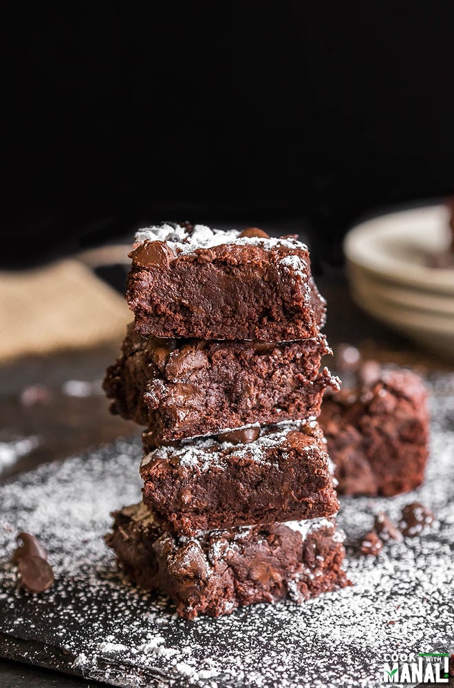 stack of 4 brownies with powdered sugar sprinkled around