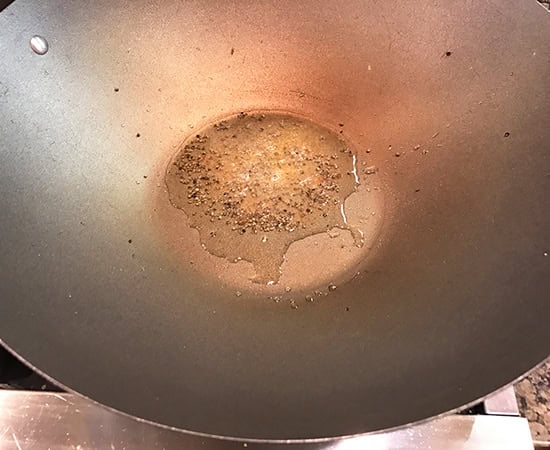 mustard seeds in oil in a kadai