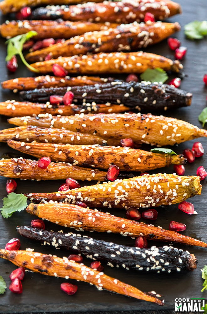 roasted baby carrots sprinkled with sesame seeds and pomegranate