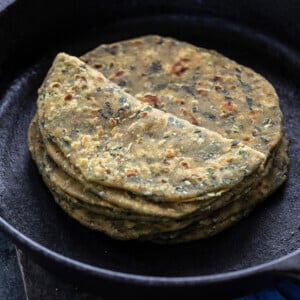 stack of methi paratha placed on a iron skillet