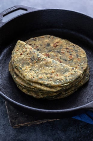 stack of methi paratha placed on a iron skillet