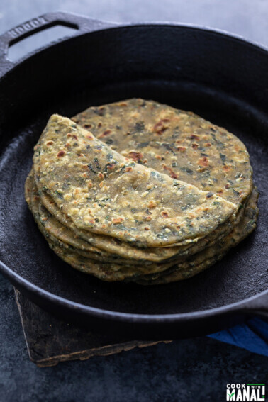 stack of methi paratha placed on a iron skillet