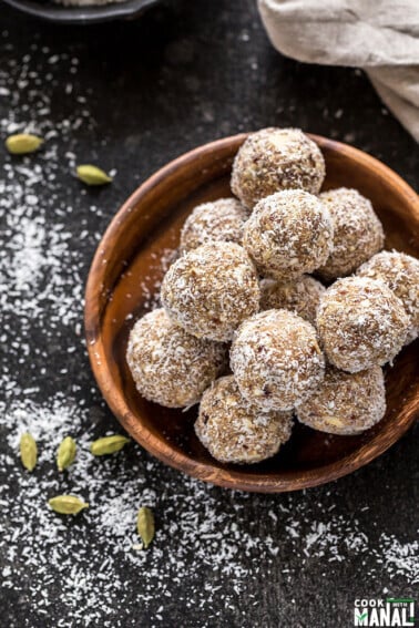 overhead shot of coconut cardamom energy bites with green cardamom pods on the side