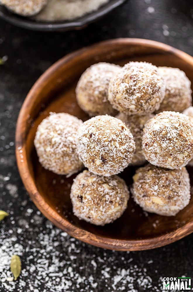 coconut cardamom energy bites in a round wooden plate