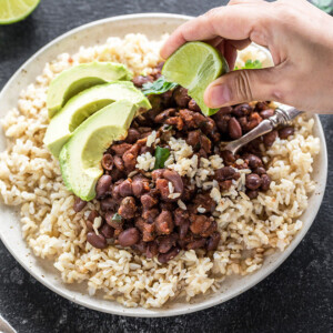 plate with beans and brown rice and avocado slices