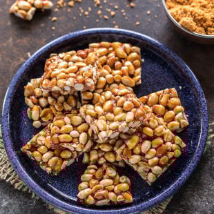 overhead shot of peanut chikki squares in a blue plate