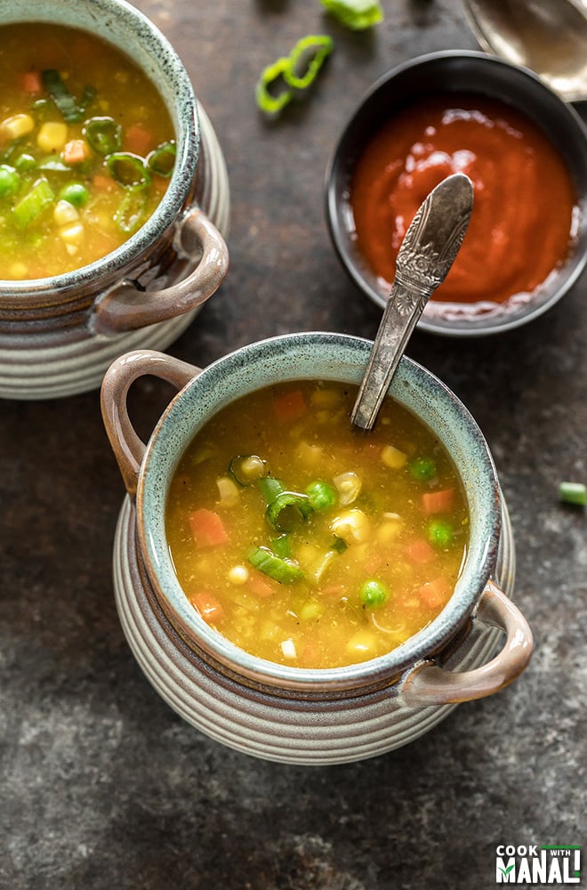 overhead shot of a bowl full of sweet corn soup with a ladle