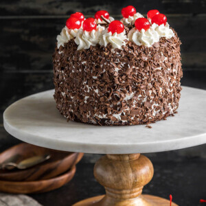 eggless black forest cake on a white marble cake stand