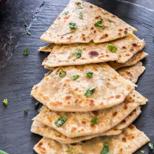 mooli paratha cut into triangular pieces and placed on a black tray