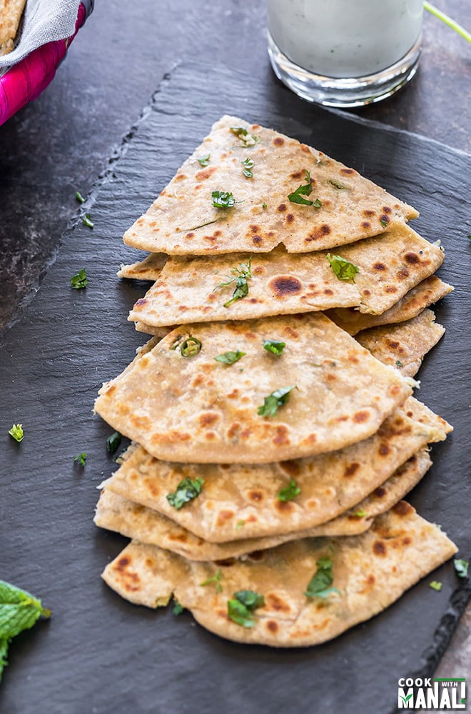 mooli paratha cut into triangular pieces and placed on a black tray