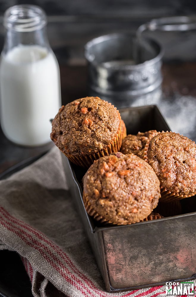 carrot muffins in a pan with a bottle of milk at the back