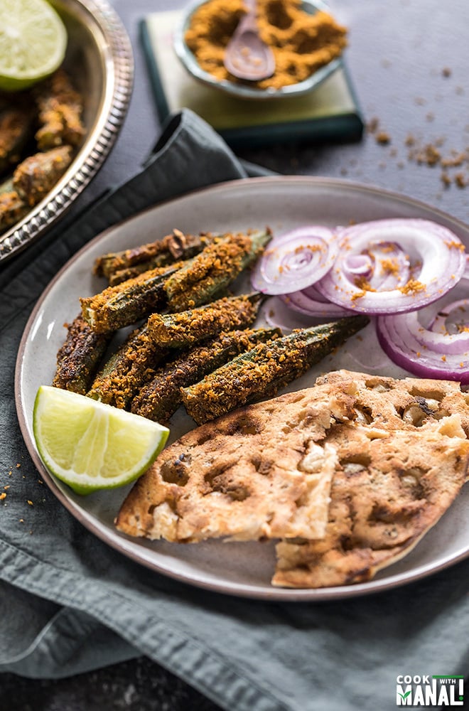 bharwa bhindi served with tandoori roti and sliced onions in a plate