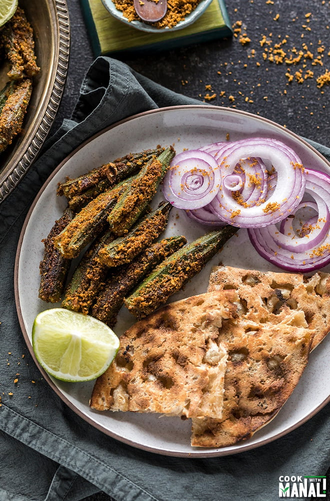 bharwa bhindi served with tandoori roti and sliced onions in a plate