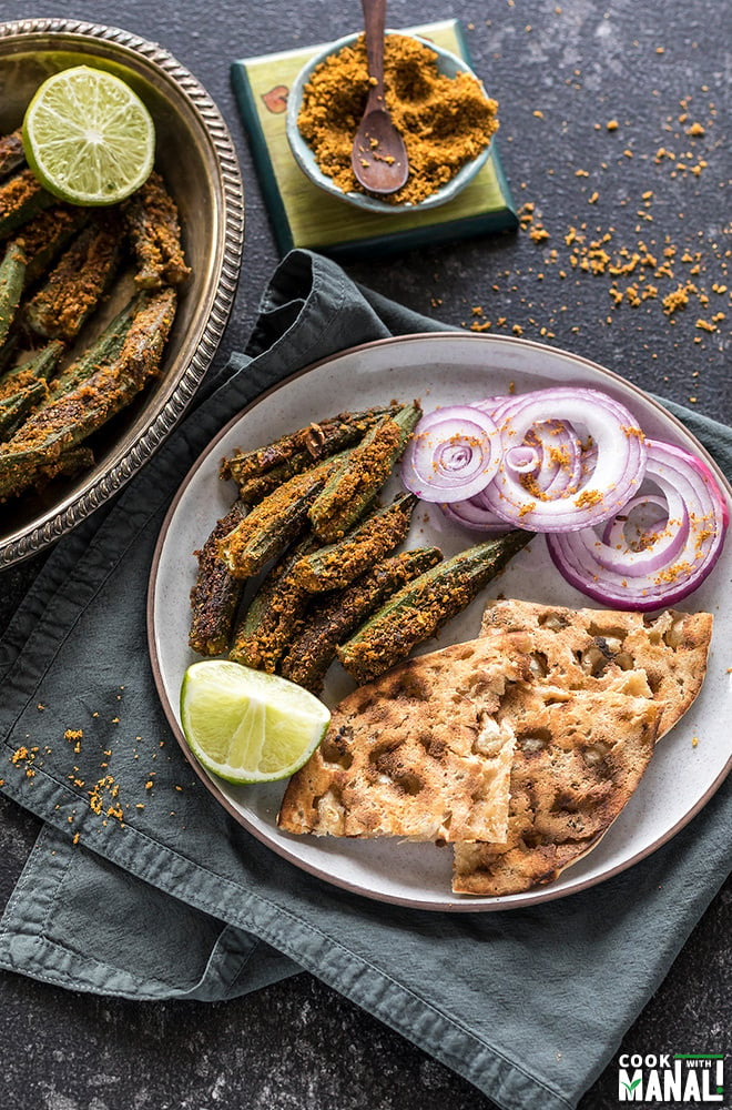 bharwa bhindi served with tandoori roti and sliced onions in a plate