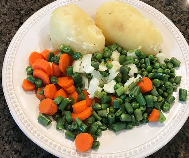 veggies and potatoes in a white plate