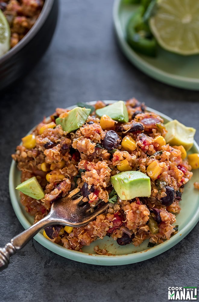 mexican quinoa served in a small blue plate with a fork on the side