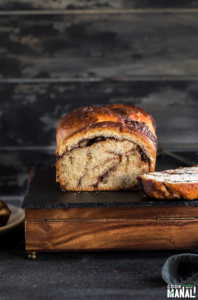 nutella babka served on a black cheese board with a cut slice on the side