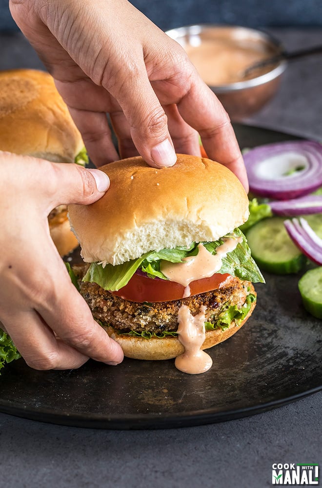 a pair of hands holding a burger