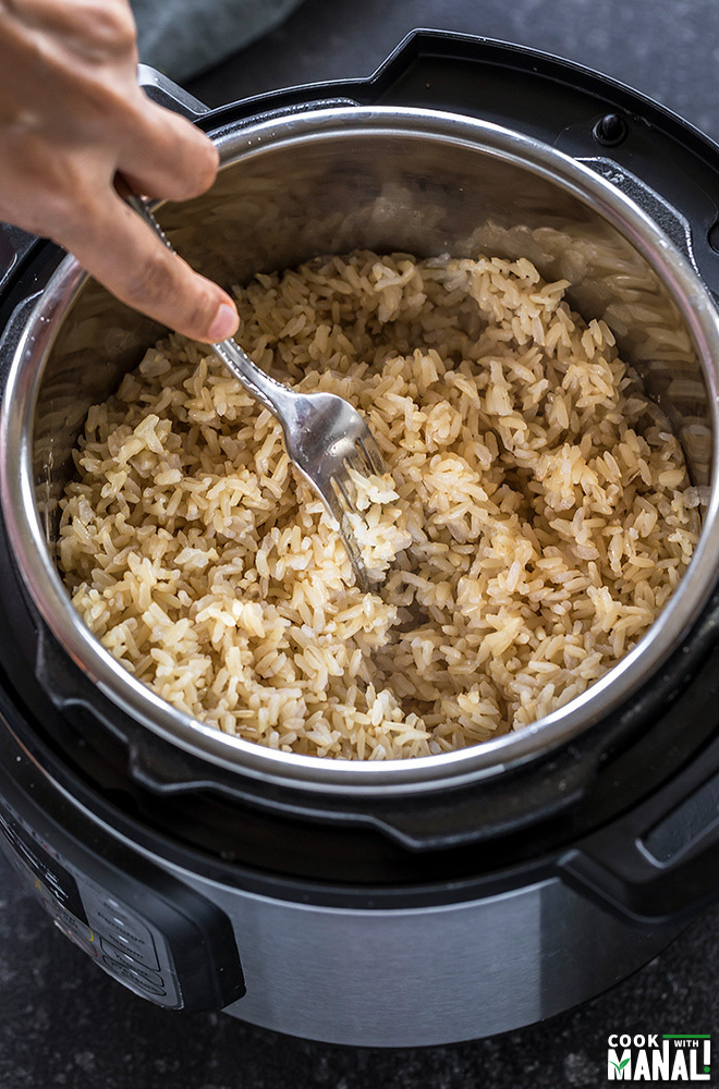 instant pot brown rice being fluffed with a fork
