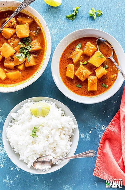 thai pumpkin curry in a white bowl served along with jasmine rice in a white bowl