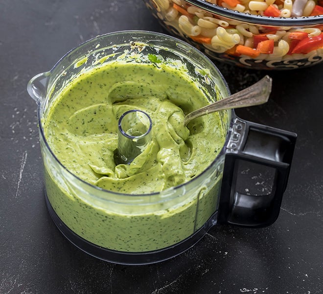 creamy green avocado dressing in a small food processor