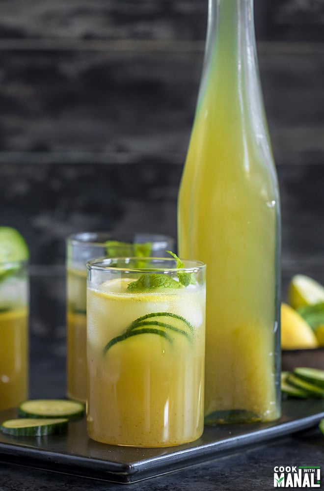 glasses of cucumber lemonade with a bottle of lemonade in the background